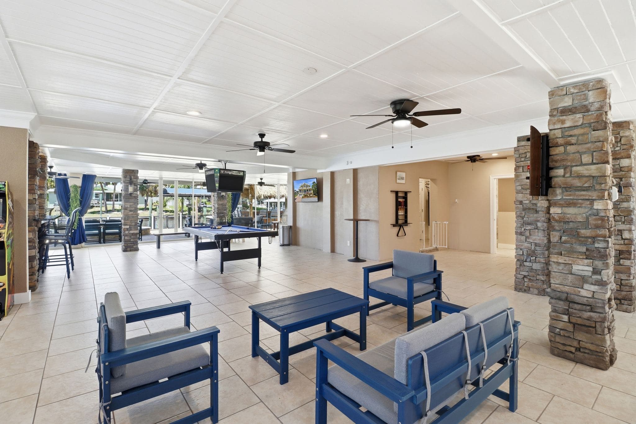 First-floor covered outdoor lounge at Bayshore Getaway with seating, ceiling fans, and canal view