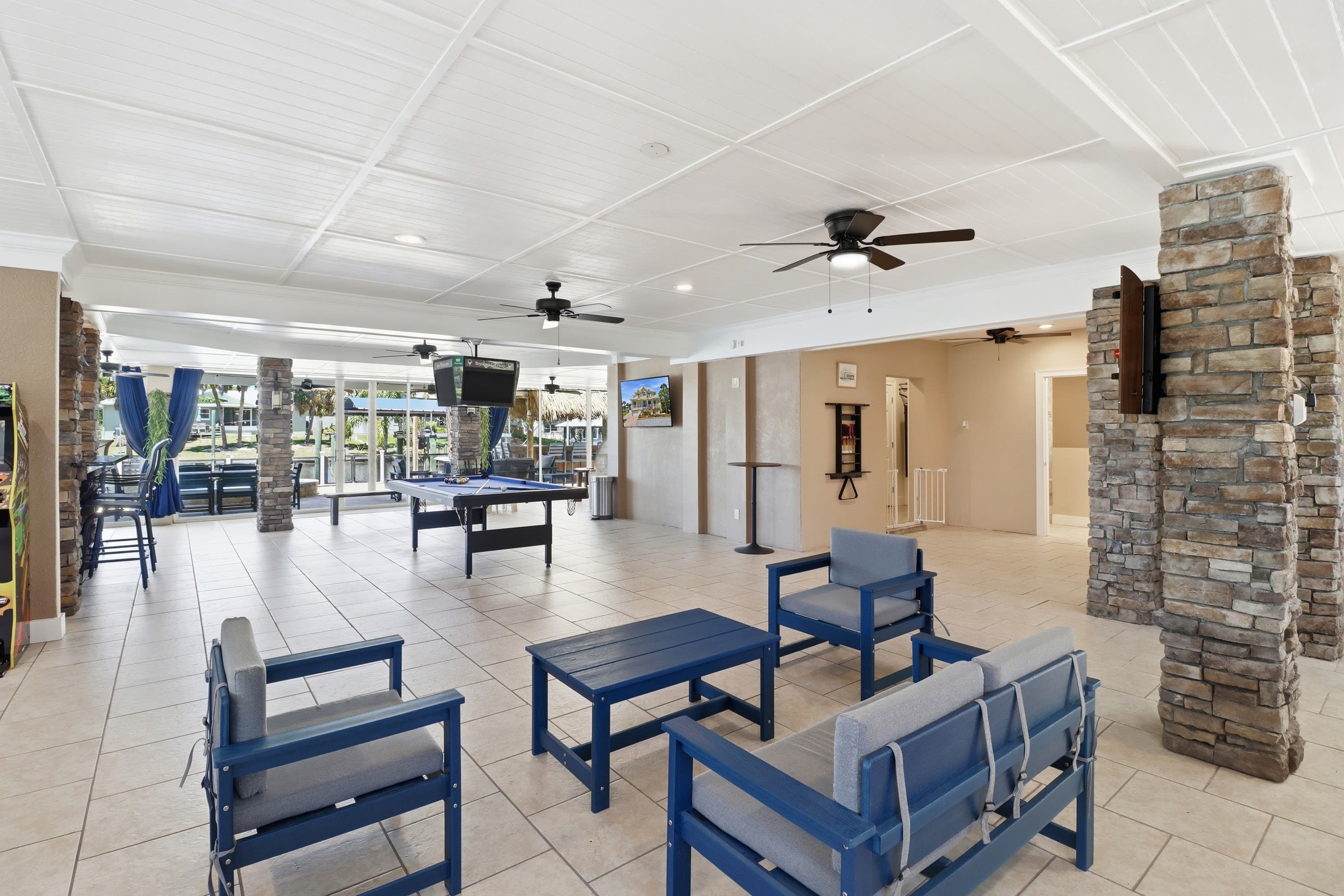 First-floor covered outdoor lounge at Bayshore Getaway with seating, ceiling fans, and canal view