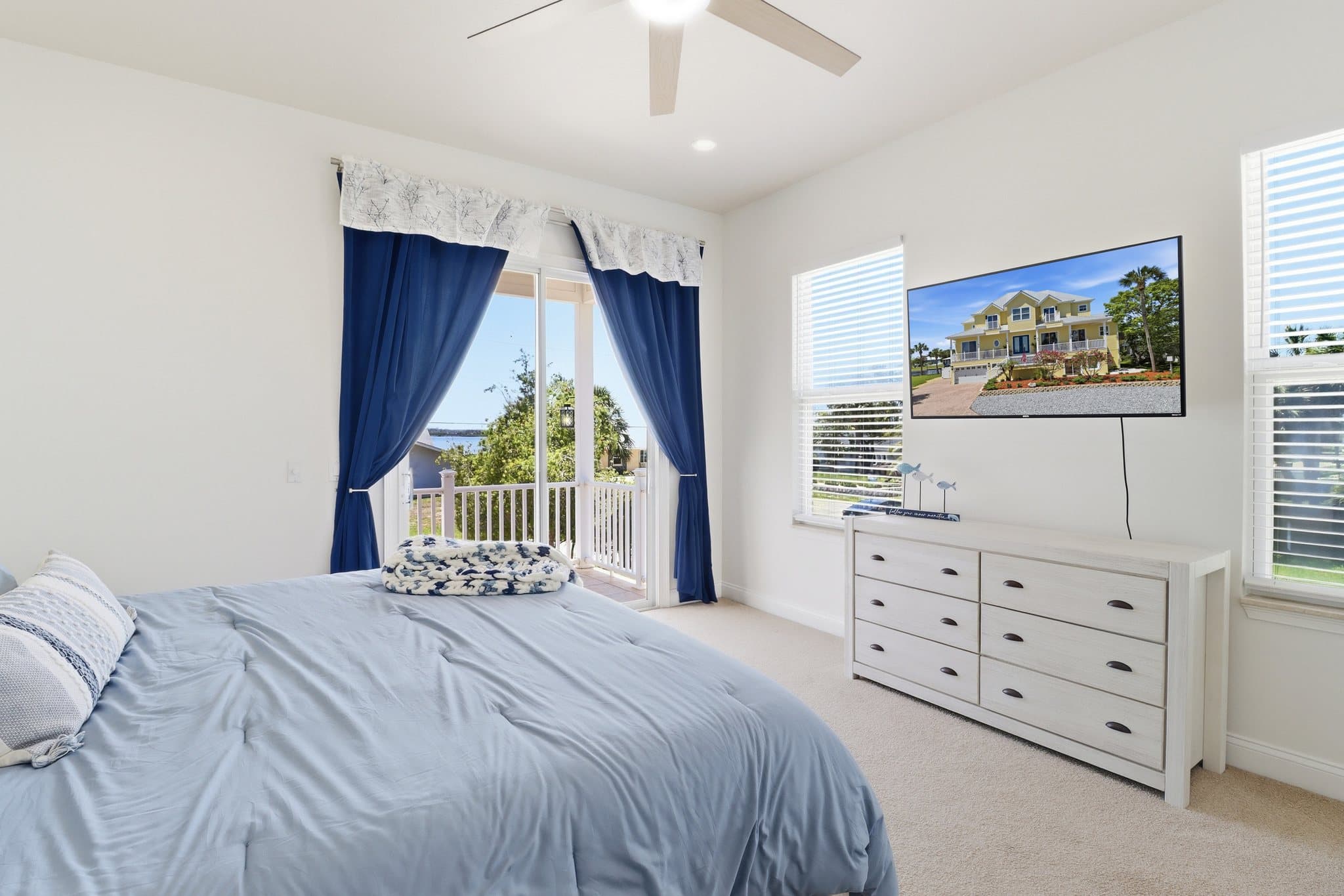 Primary bedroom with private balcony and TV